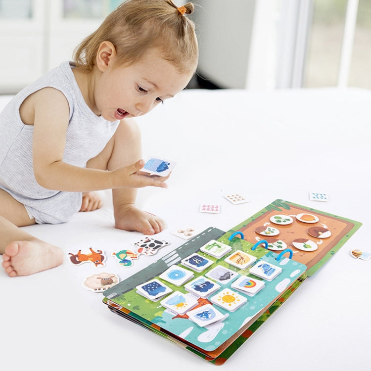 Busy book learning toy with sticker matching, child using it on tabletop