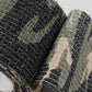Close-up of camouflage non-woven tape texture on rolled edge, dark and green