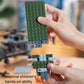 Hands assembling green building block plates for the helicopter model kit.