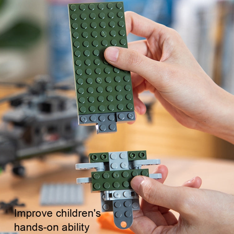 Hands assembling green building block plates for the helicopter model kit.