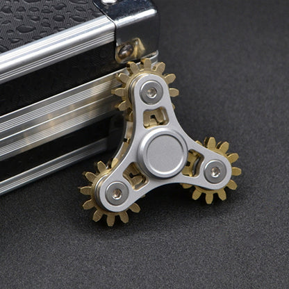 Four-gear fidget spinner with silver frame and gold-tone gears, circular center cap.