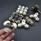 Four-gear fidget spinner cluster with silver and black styles, hand holding one spinner.