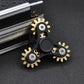 Four-gear fidget spinner with black frame, gold-tone gears, and dark center disc.