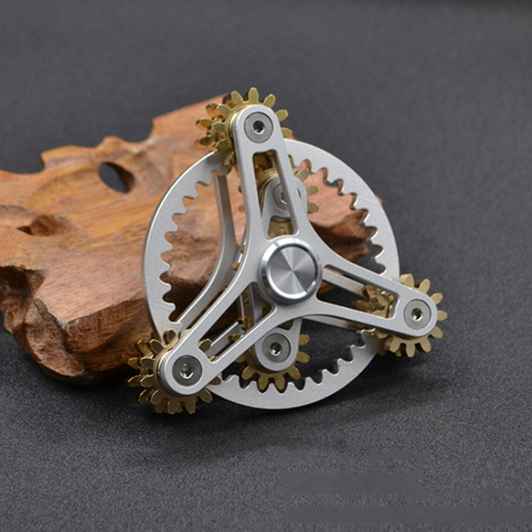 Four-gear fidget spinner with silver frame and gold-tone gears, round center medallion.