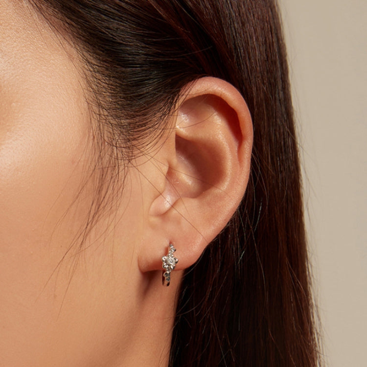Sterling silver hoop earrings with small flower and zircon accents on ear
