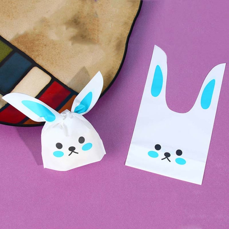 Rabbit-ear gift bag, white with blue ears and cartoon cat/bunny face, tied closed.