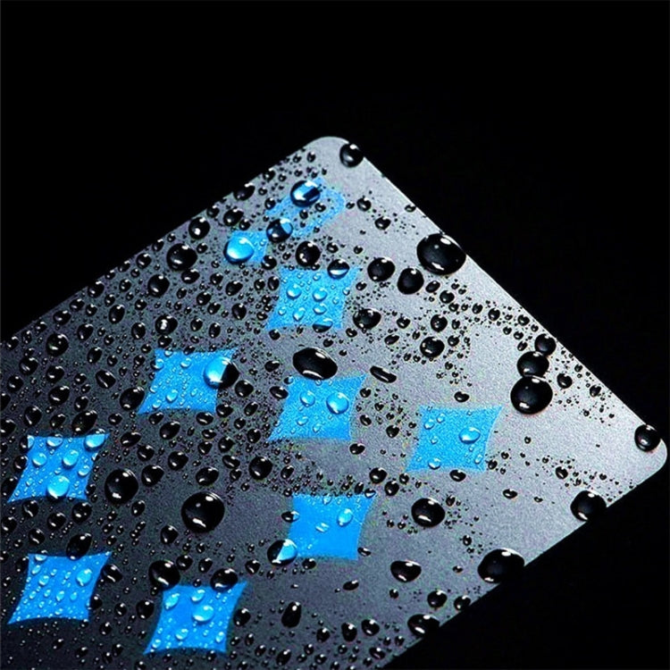 Close-up of waterproof PVC playing card with blue pattern and water droplets