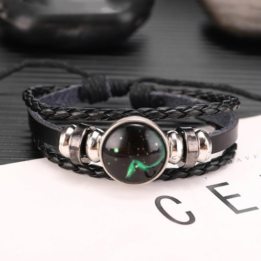 Black braided leather bracelet with silver-tone beads and a round green celestial charm.