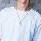 Poker card pendant necklace worn on chest with red heart symbols on silver tag and chain