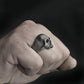 Skull ring on hand, small silver-tone skull face with cracked texture