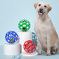 Hollow rubber dog bite balls in blue, green, and red beside a sitting dog
