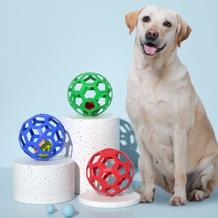 Hollow rubber dog bite balls in blue, green, and red beside a sitting dog