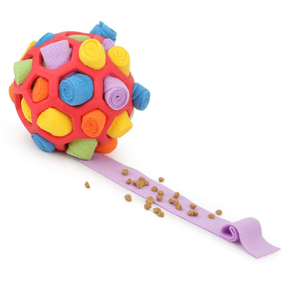 Multicolor plush dog sniffing ball with purple treat-feeding strip and scattered kibble