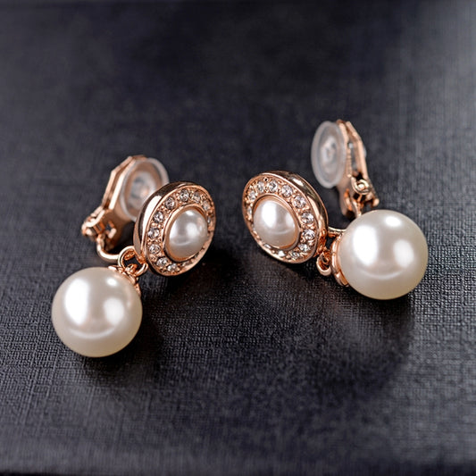 Gold tone pearl ear clip earrings with oval bezel crystals and two pearl drops