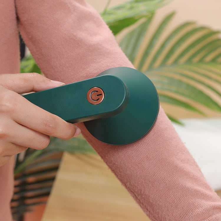 Green rechargeable hair trimmer held in hand, with top power button visible