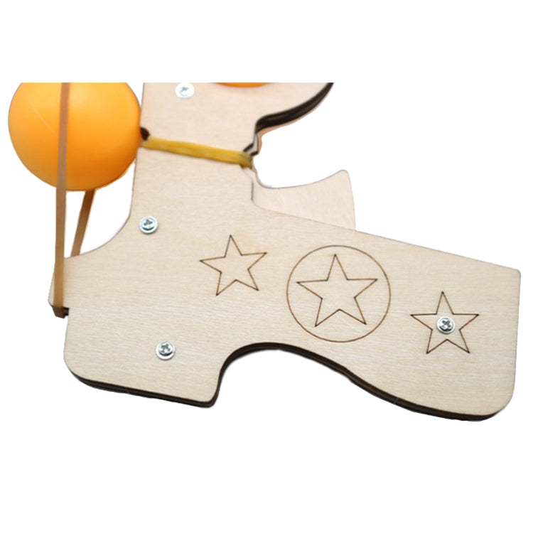Wooden launcher toy close-up with star engravings, yellow balls, and elastic bands