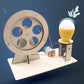 Wooden hand generator puzzle with circular wheel, glowing yellow bulb, and wire leads