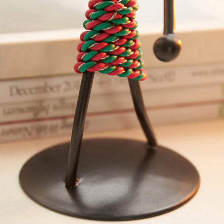 Close-up of colorful braided coiled body on man-shaped metal candlestick ornament