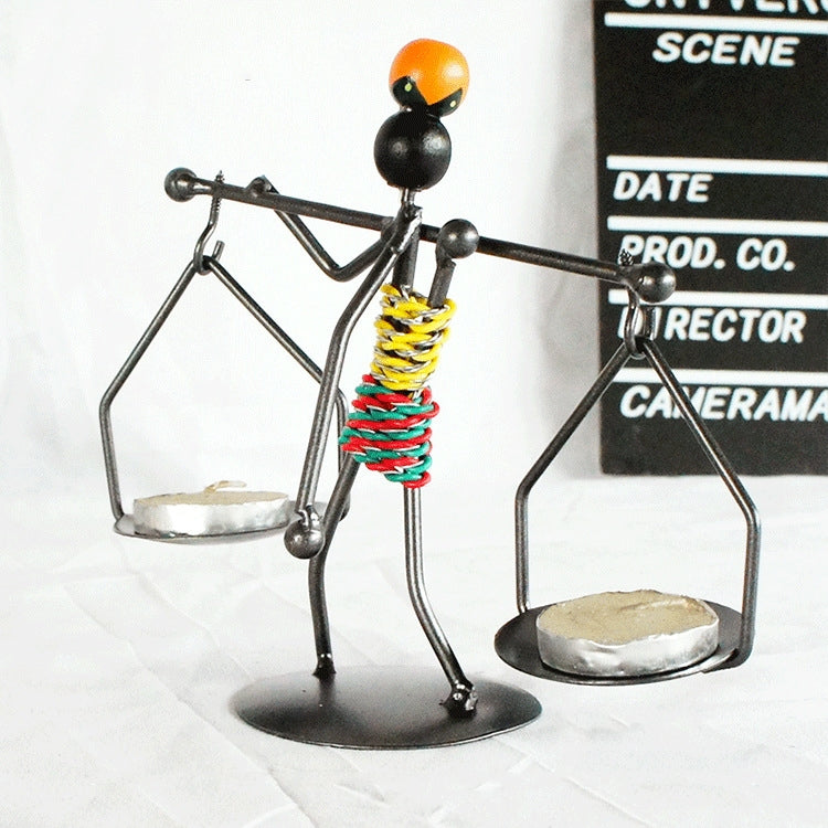 Man-shaped metal candlestick ornament with arms holding trays and colorful coiled body