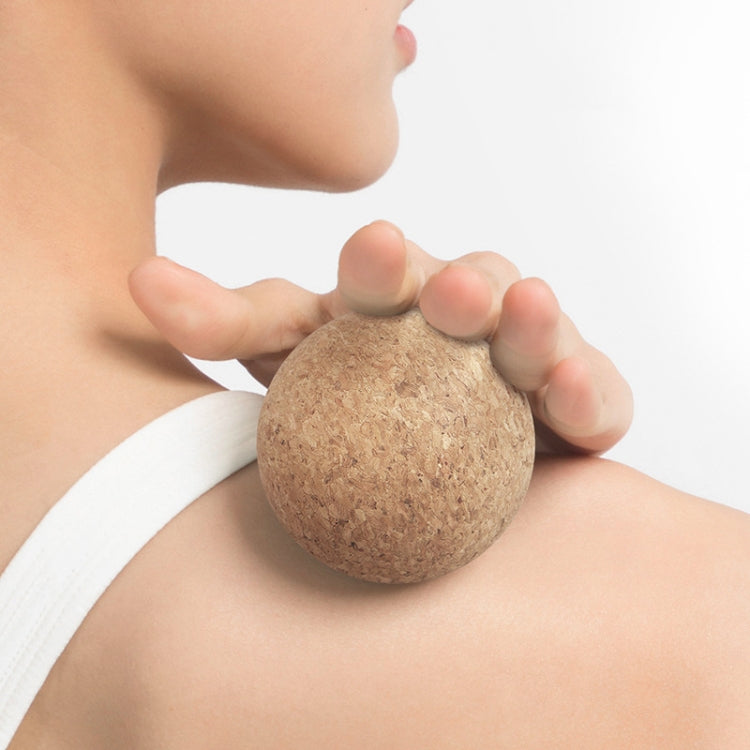 Cork fascia massage ball held against the neck for self-massage.