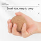 Small tan cork massage ball held in two hands.