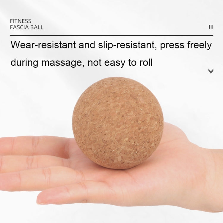 Tan cork massage ball resting in an open palm.