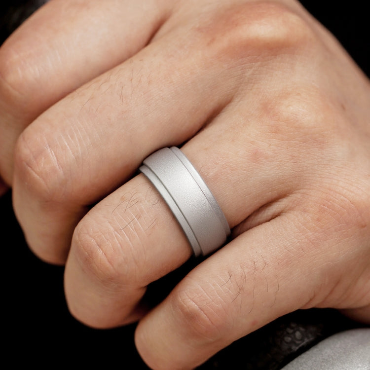 Curved silicone step ring on finger, silver-gray matte ring close-up