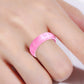 Pink glitter silicone ring with wide band, worn on finger.