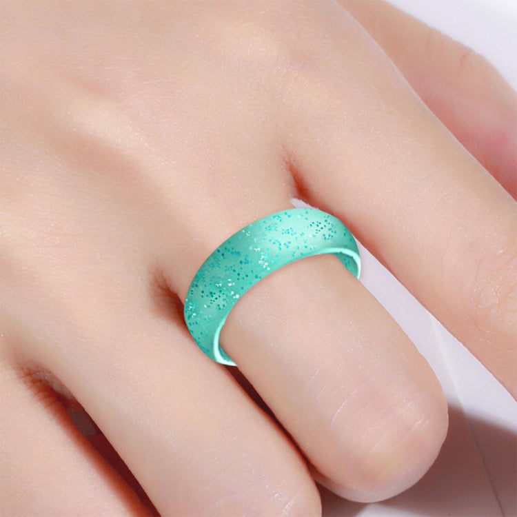 Teal glitter silicone ring, wide band, worn on finger close-up.