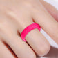 Wide pink silicone ring band on finger, close-up