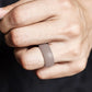 Curved dark gray silicone sports ring on finger, wide band matte look