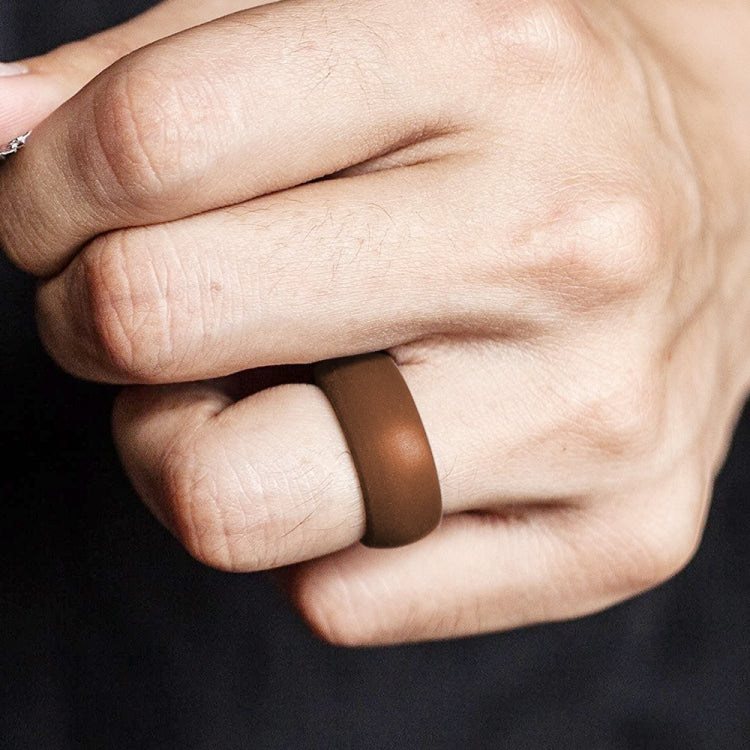 Curved brown silicone sports ring on finger, smooth matte band