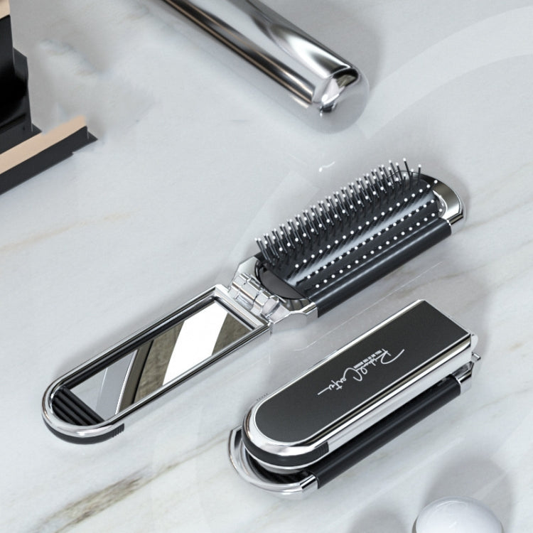 Foldable black hair comb with integrated mirror and silver handle, massage bristles