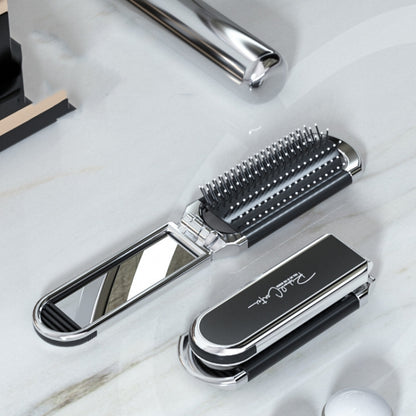 Foldable black hair comb with integrated mirror and silver handle, massage bristles