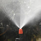 Orange drip irrigation spray head releasing a mist spray