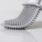 Soft rubber toilet brush head with dense gray bristles and clamp handle