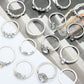 Assorted silver-tone rhinestone rings with heart and water-drop charms on display