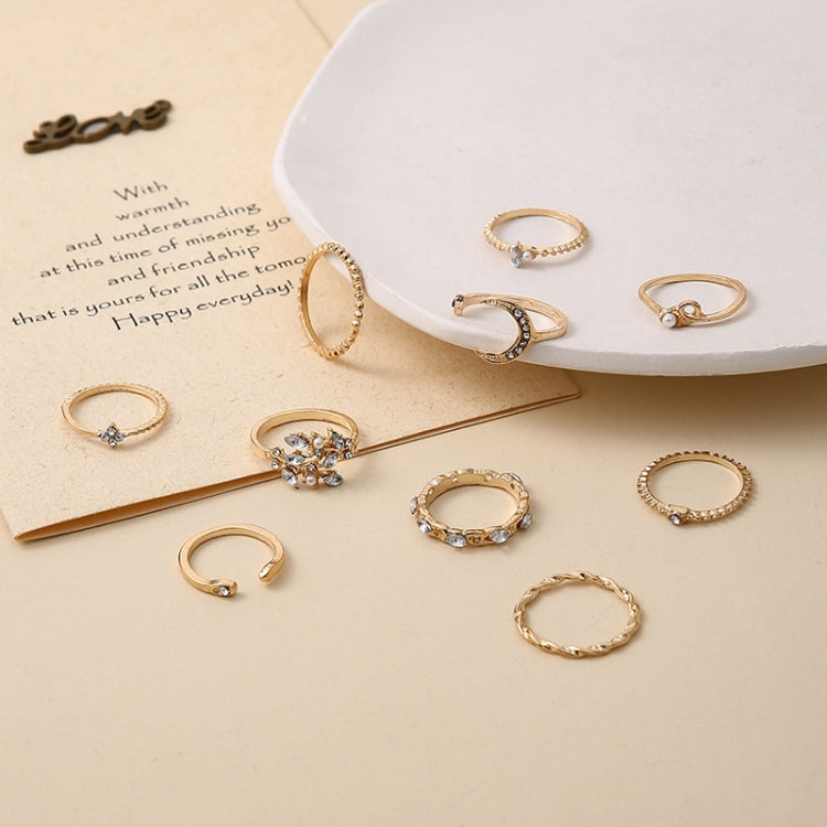 Gold-tone rhinestone knuckle rings laid on card, crescent, heart, and star motifs