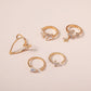Gold-tone knuckle rings with heart, butterfly, cross, and bow motifs with stones