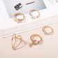 Gold-tone knuckle rings on display: heart, cross, and butterfly designs with stones