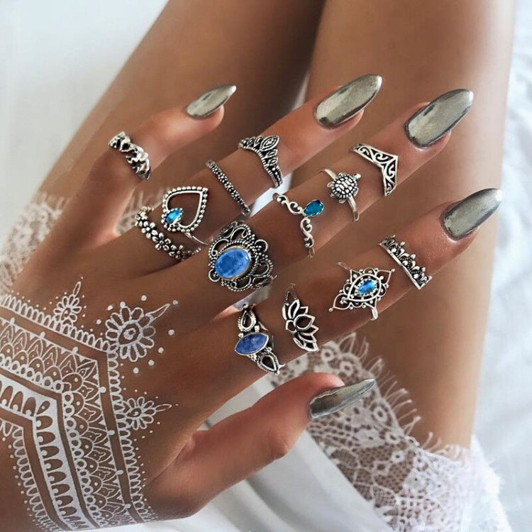 Set of 13 silver-tone rings with blue gemstones, worn on hand