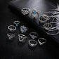 Set of 13 silver-tone rings with blue gemstone details, arranged for close view