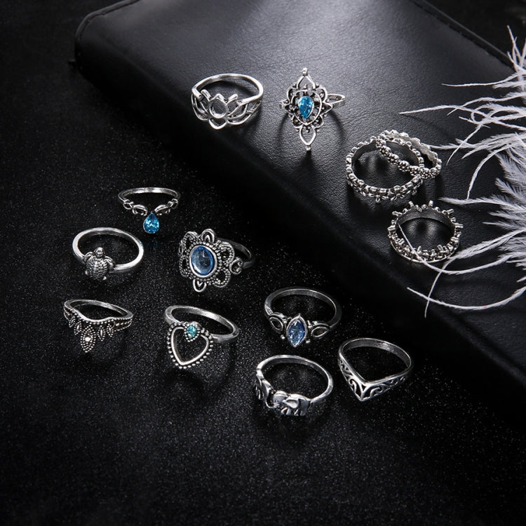 Set of 13 silver-tone rings with blue gemstone details, arranged for close view
