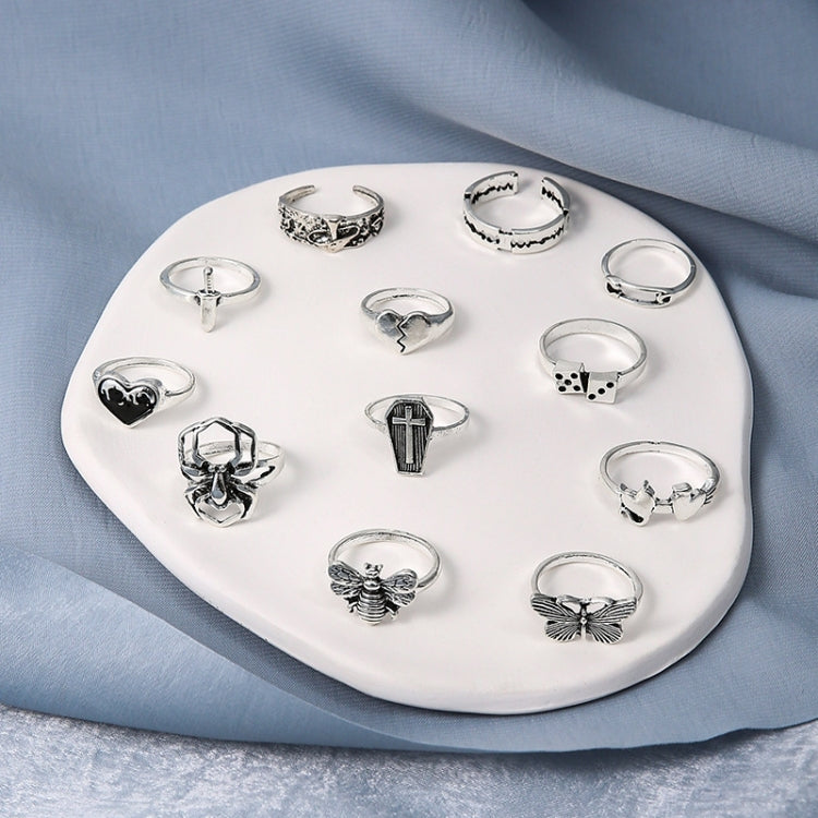 12-piece open ring set laid on tray, featuring heart, cross, butterfly, and spider designs