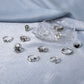 Open ring set on fabric with multiple gothic charms, including cross, butterfly, and spider