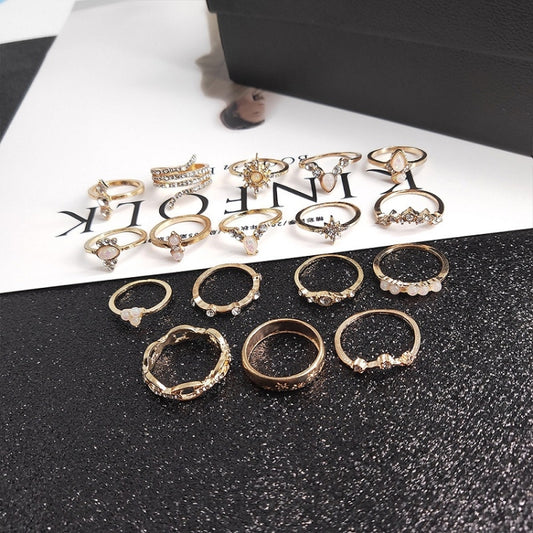 Gold-tone ring set with multiple crystal and pearl-like stone designs, 17 rings