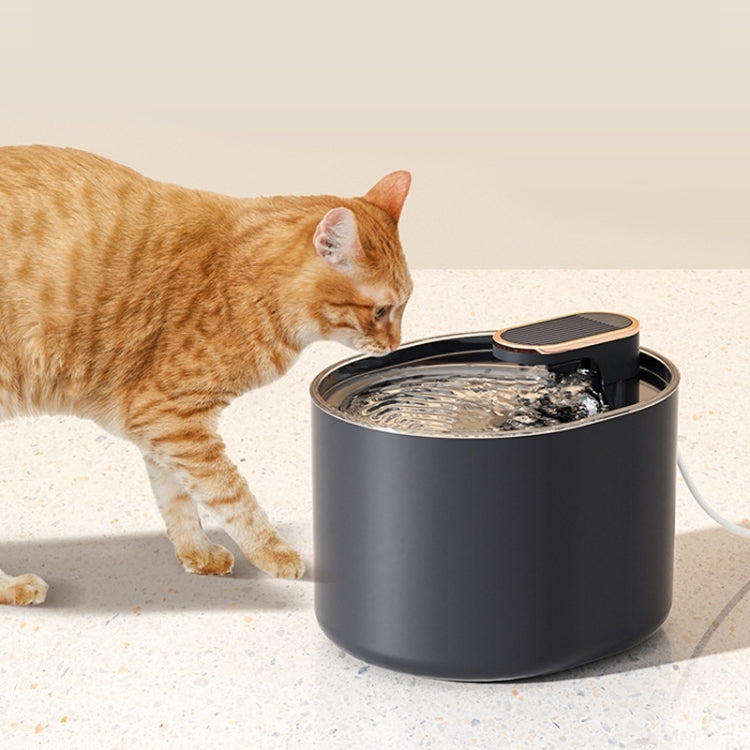 Cat drinking from a black automatic pet water fountain with open top
