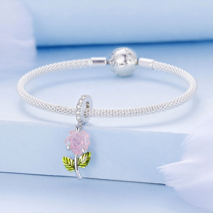 Sterling silver bracelet with light pink rose charm, green enamel leaves, and clasp bead