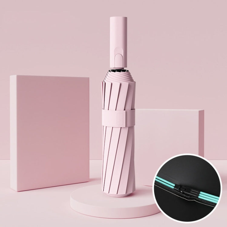 Pink automatic umbrella, closed with strap and button handle