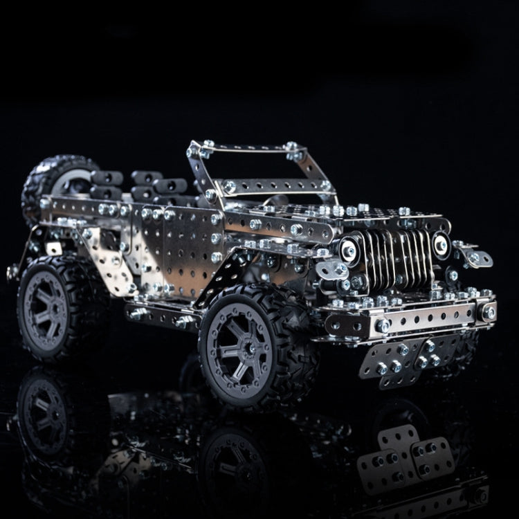 Metal off-road vehicle model toy with silver panels, black wheels and rugged tires, side view